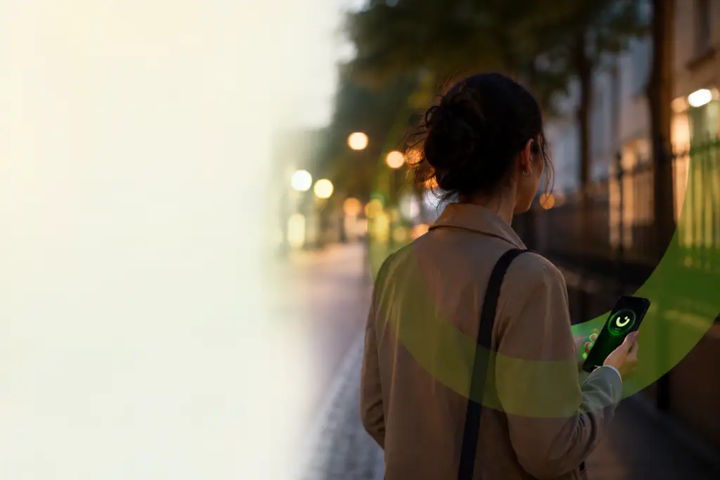 Femme marchant sereinement le soir avec l'application GoSafeMorse activée sur son téléphone